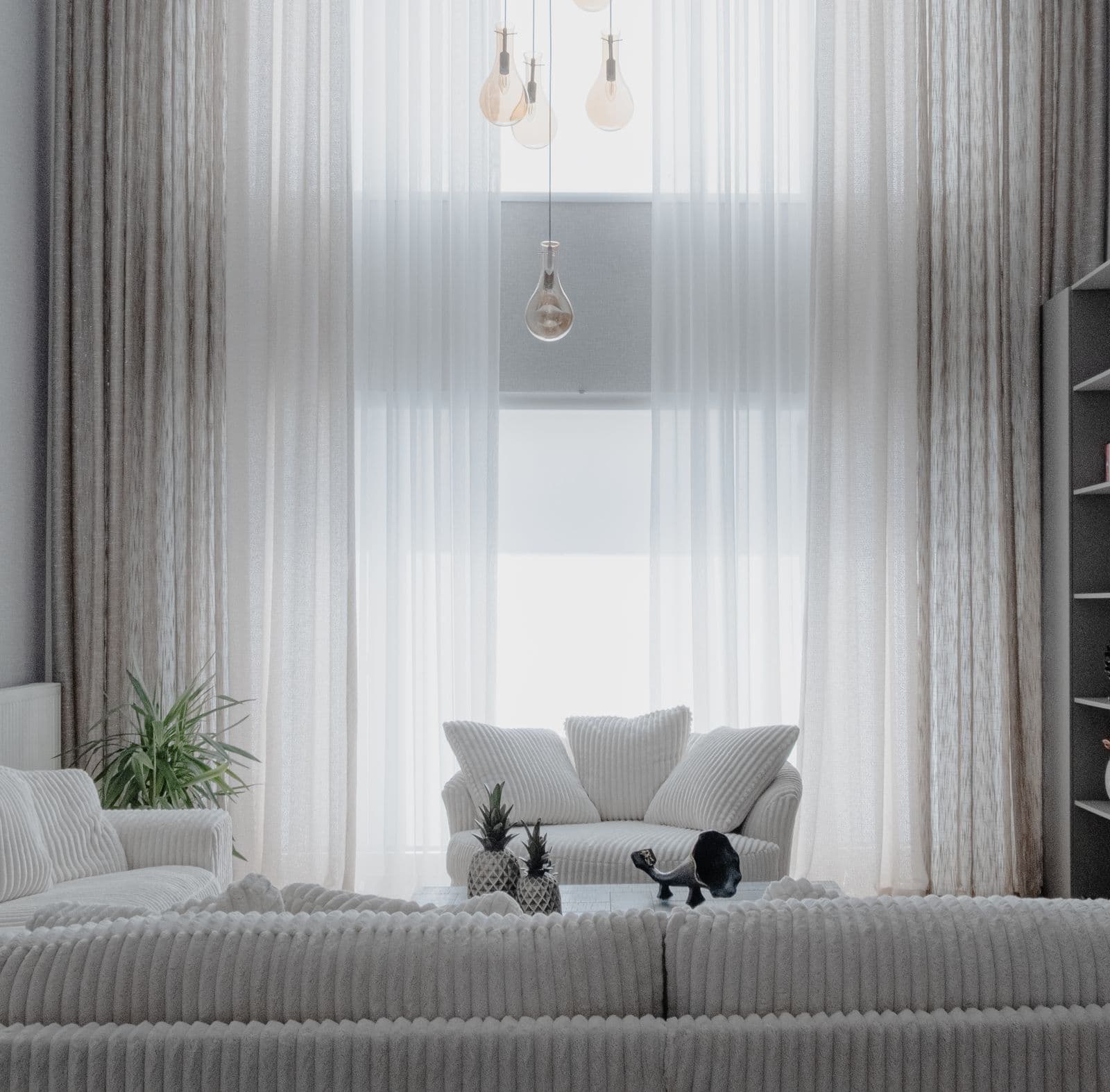 Bright, airy modern living room with sheer curtains and pendant lighting